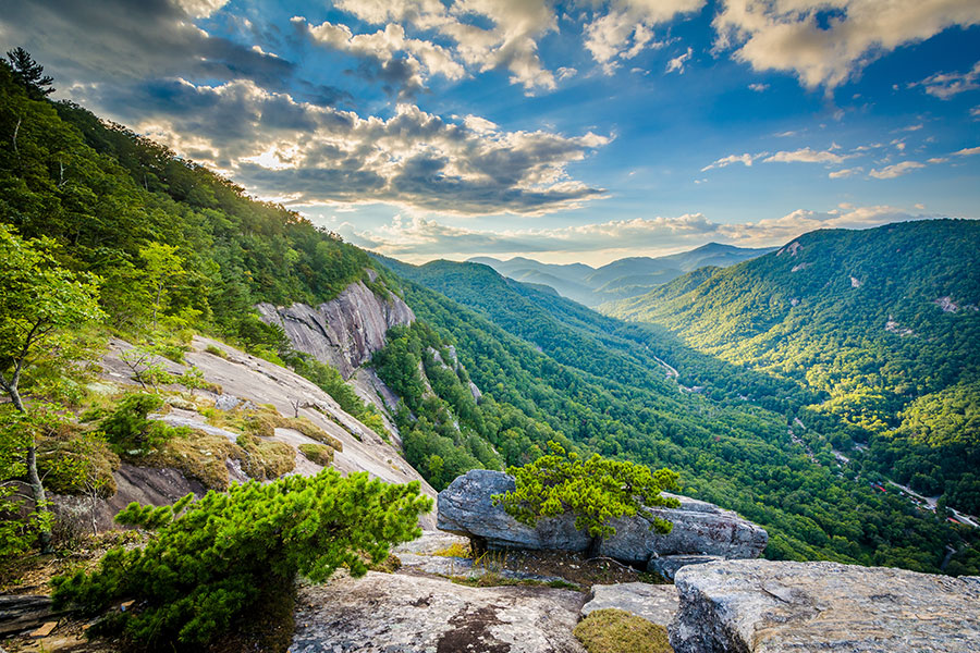 About - Scenic Green Mountains with Sun Rays and Blue Sky